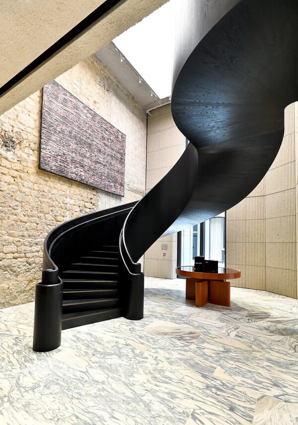 마크 브래드포드의 콜라주 페인팅이 2층으로 이어지는 나선형 계단을 따라 설치돼 있다. 사진 Dominique Maître/WWD